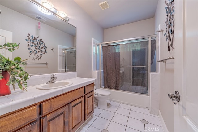 full bathroom featuring tile patterned floors, shower / bath combination with glass door, vanity, and toilet