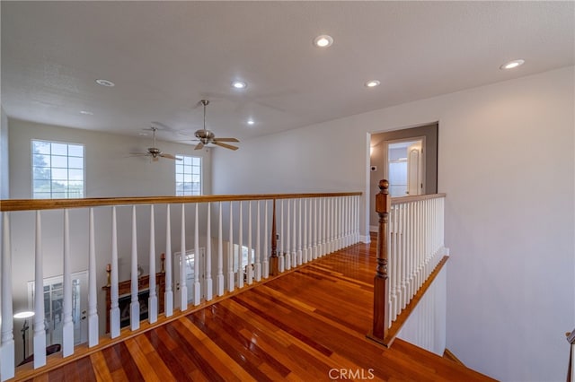 hall with a healthy amount of sunlight and hardwood / wood-style floors