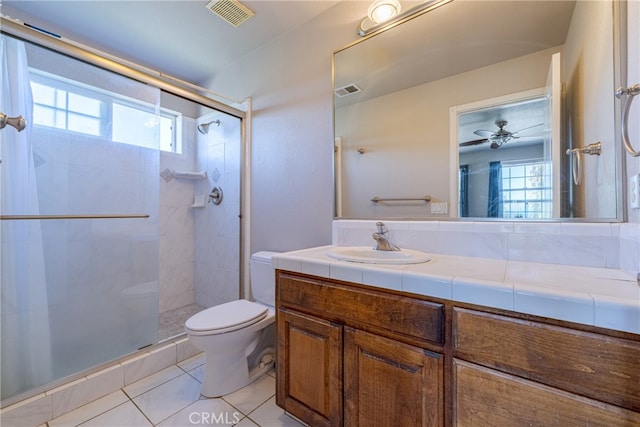 bathroom with ceiling fan, toilet, tile patterned floors, a shower with shower door, and vanity