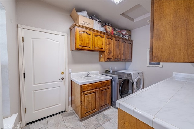 laundry room with washer and dryer, cabinets, and sink