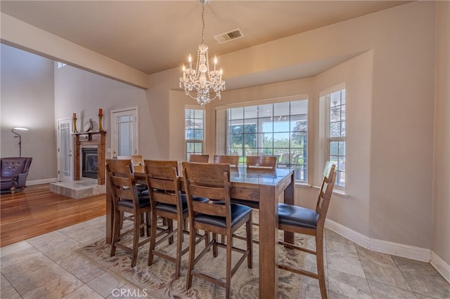 dining room with light hardwood / wood-style floors and a notable chandelier