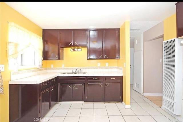 kitchen featuring tile counters, light tile patterned flooring, and sink