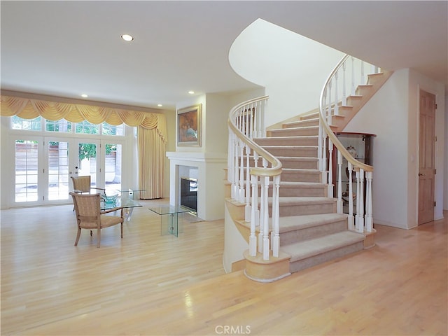 stairs with hardwood / wood-style flooring and french doors