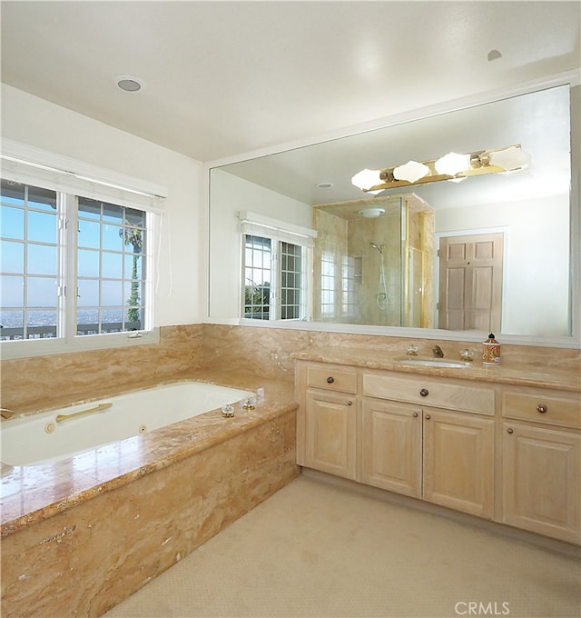 bathroom featuring shower with separate bathtub and vanity