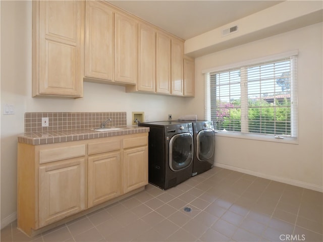 laundry room featuring light tile patterned floors, cabinets, sink, and independent washer and dryer