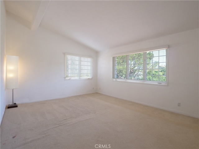 spare room featuring light carpet and vaulted ceiling with beams