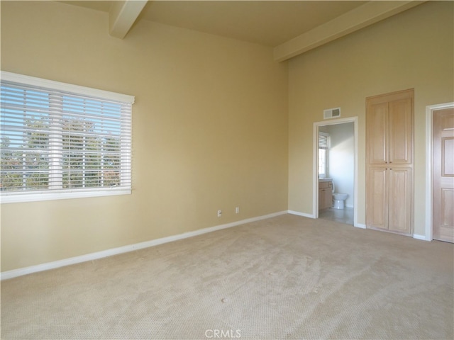 empty room featuring light carpet and beam ceiling