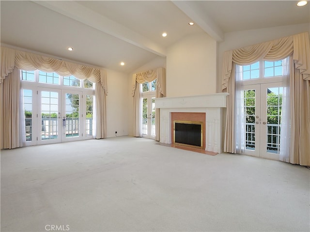 unfurnished living room with high vaulted ceiling, carpet floors, beamed ceiling, a high end fireplace, and french doors