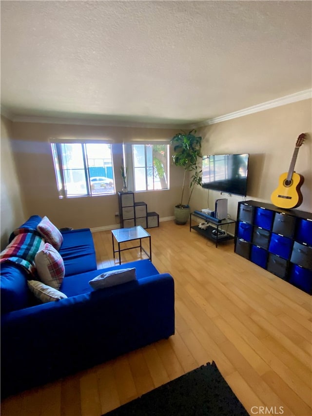 living room featuring hardwood / wood-style flooring, a healthy amount of sunlight, and crown molding