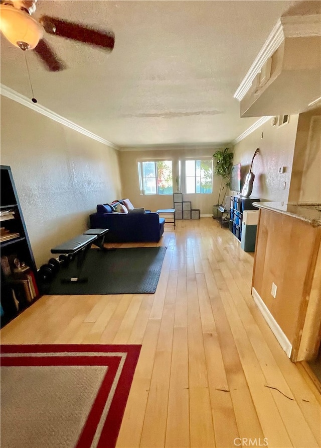 living room with ceiling fan, hardwood / wood-style flooring, and crown molding