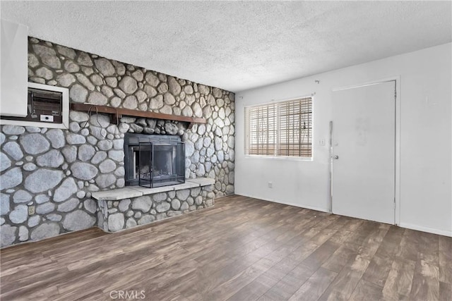 unfurnished living room featuring a fireplace, wood-type flooring, and a textured ceiling