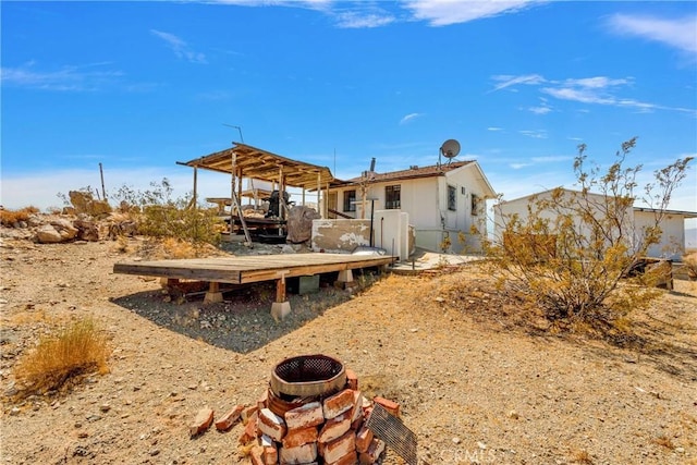 back of property featuring a fire pit