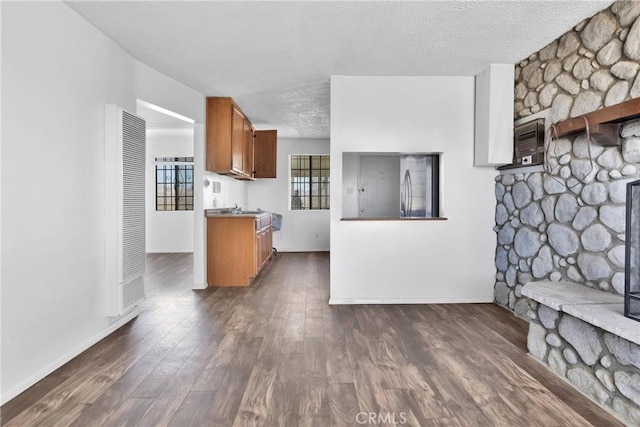 kitchen with a textured ceiling and dark wood-type flooring