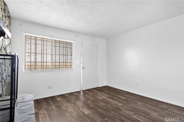 spare room with dark hardwood / wood-style flooring and a textured ceiling