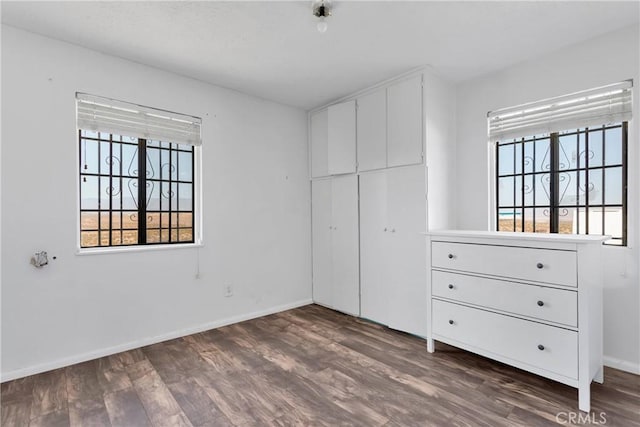 unfurnished bedroom with dark hardwood / wood-style flooring