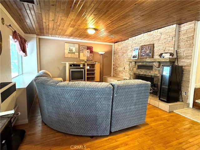 living room featuring crown molding, a stone fireplace, hardwood / wood-style floors, and wooden ceiling