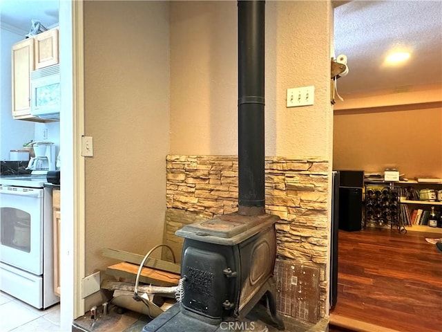 details featuring hardwood / wood-style floors, white appliances, and a wood stove