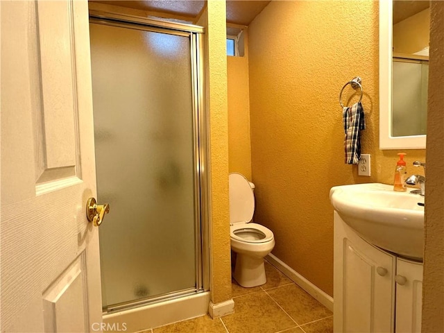 bathroom featuring a shower with door, vanity, tile patterned flooring, and toilet