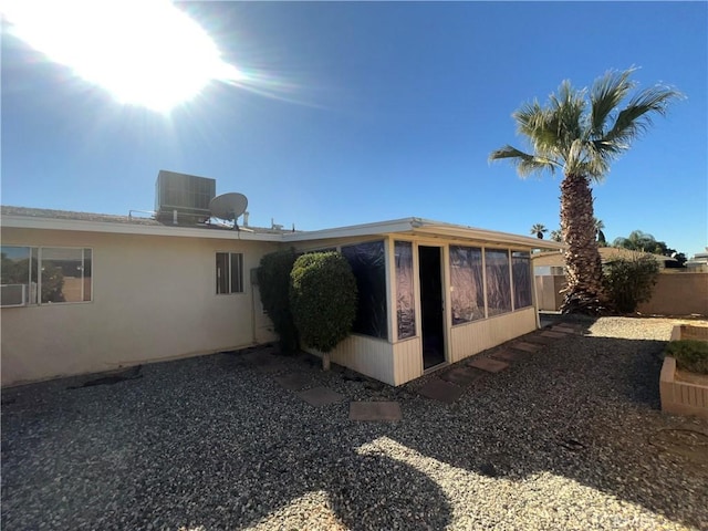 rear view of house with a sunroom and cooling unit