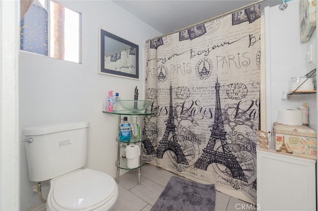 bathroom featuring tile patterned floors, a shower with curtain, and toilet