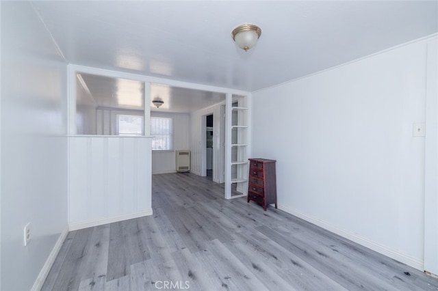 unfurnished room featuring heating unit and light wood-type flooring