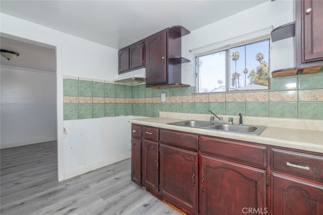 kitchen with light hardwood / wood-style flooring, sink, and backsplash