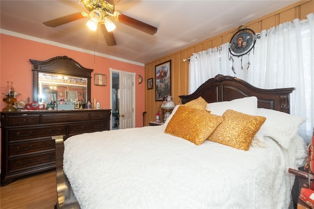 bedroom with crown molding, wood-type flooring, and ceiling fan