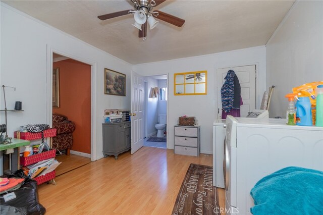 laundry room with ornamental molding, separate washer and dryer, light wood-type flooring, and ceiling fan