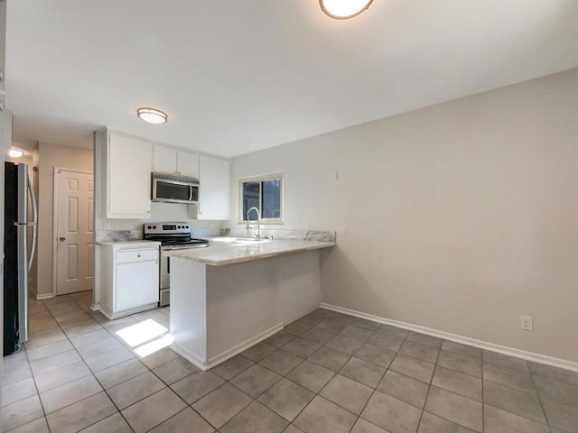 kitchen with white cabinets, sink, light tile patterned floors, kitchen peninsula, and stainless steel appliances