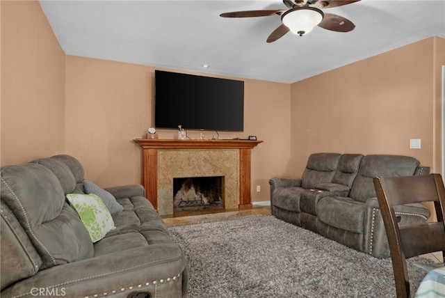 living room featuring ceiling fan and a fireplace