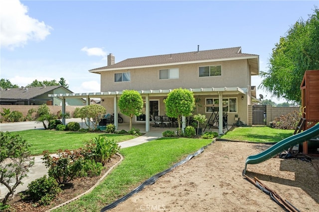 rear view of property with a playground, a pergola, a patio area, and a lawn