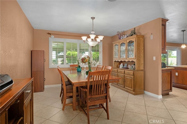 tiled dining area featuring a chandelier