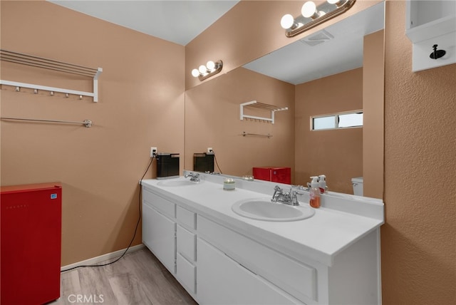 bathroom with hardwood / wood-style floors, vanity, and toilet