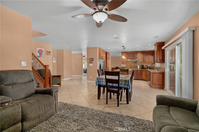 living room featuring light tile patterned floors, ceiling fan, and sink