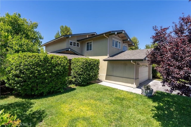 rear view of house featuring a garage and a yard