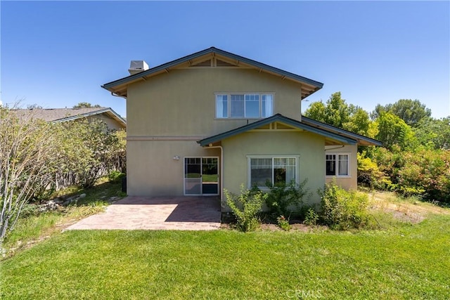 rear view of property with a lawn and a patio area