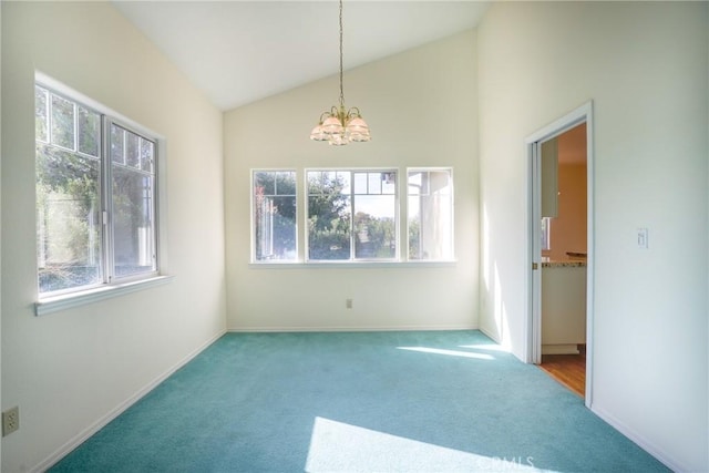 carpeted spare room featuring plenty of natural light, high vaulted ceiling, and a chandelier