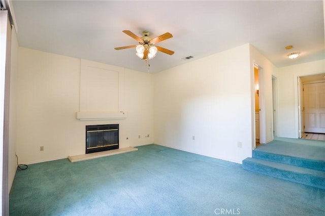 unfurnished living room featuring carpet flooring, ceiling fan, and a fireplace