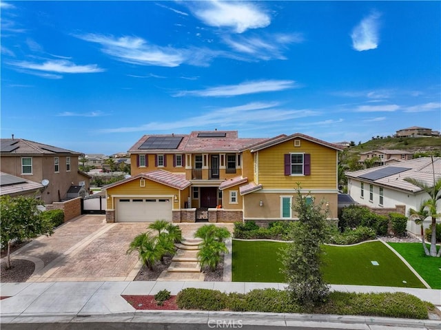 view of front of property with a balcony, a front lawn, a garage, and solar panels