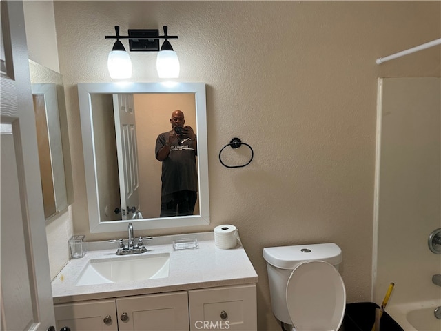 full bathroom featuring toilet, vanity, and  shower combination