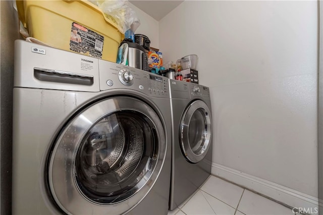 laundry room with light tile patterned floors and washing machine and clothes dryer