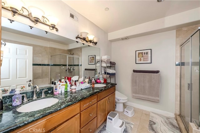 bathroom featuring vanity, toilet, tile patterned floors, and walk in shower