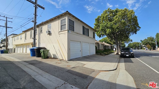 view of side of property featuring cooling unit and a garage