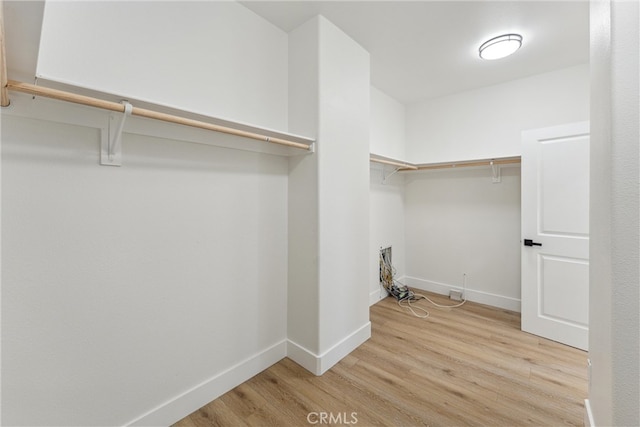 spacious closet with light hardwood / wood-style flooring