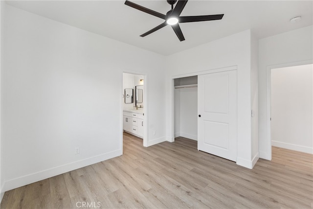 unfurnished bedroom with a closet, light hardwood / wood-style floors, ensuite bathroom, and ceiling fan