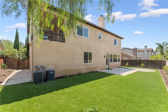 rear view of property featuring a lawn, a patio area, and central air condition unit