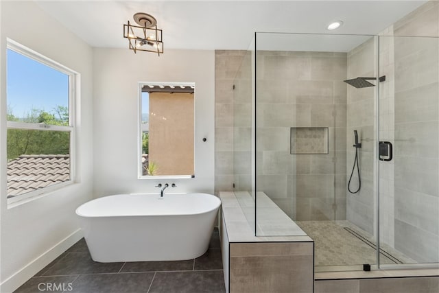 bathroom with plus walk in shower, tile patterned floors, and a healthy amount of sunlight