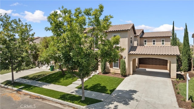 mediterranean / spanish house featuring a garage and a front lawn