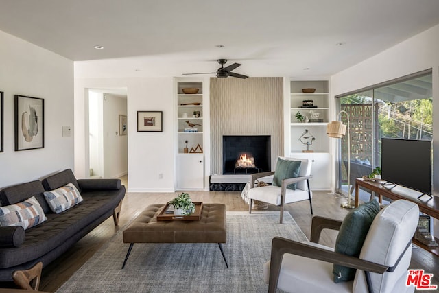 living room with a fireplace, hardwood / wood-style floors, and ceiling fan