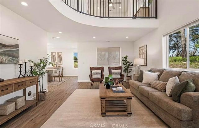 living room featuring wood-type flooring and a towering ceiling